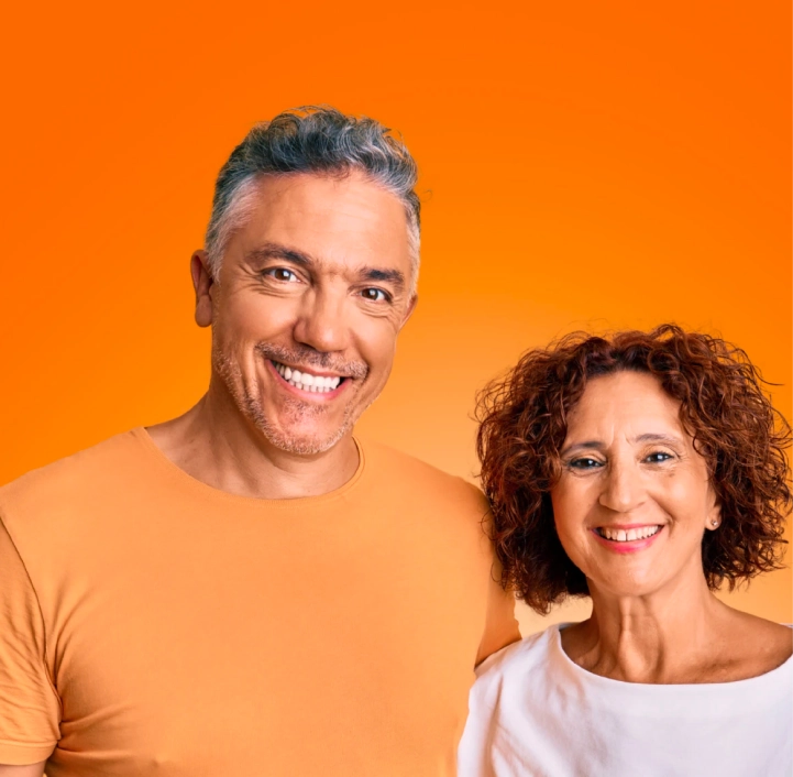 homem de camiseta laranja e mulher de blusa branca sorrindo